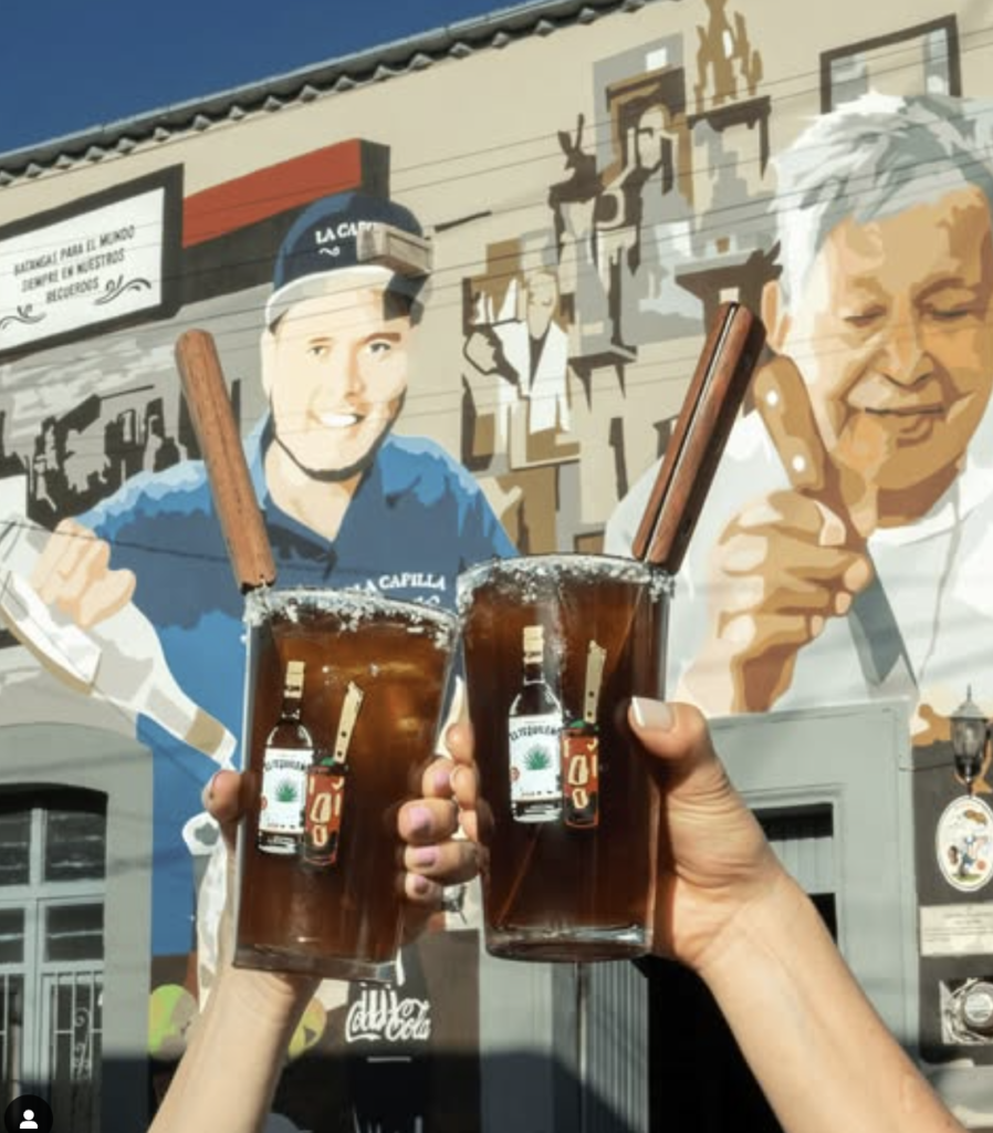 Guests toasting Batanga cocktails in front of Don Javier mural in Tequila, Jalisco — a stop on TQM’s private tequila tour