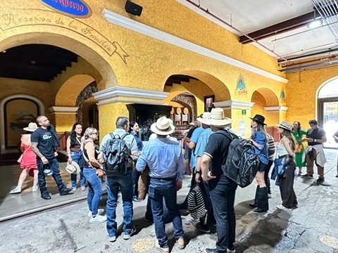 Los huéspedes que entran el tequila patio con amarillo de los arcos en el José Cuervo Express Premium Plus y La Rojeña la Destilería de Tequila, México.