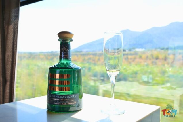Bottle of Tres Generaciones Añejo tequila and a champagne glass on the Tequila Express Train.