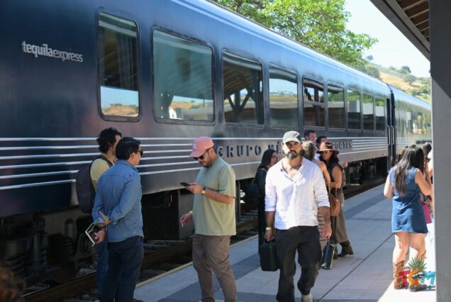 Crowds walking alongside the Tequila Express train at the station during a TQM Tours excursion.