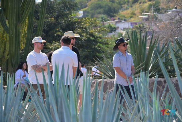 Group of men wearing hats standing among agave plants during the Tequila Express Train tour.