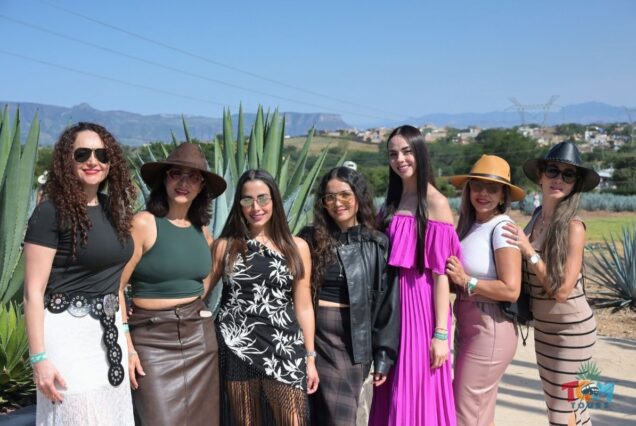 Group of women posing together in the agave fields during the Tequila Express Train tour.