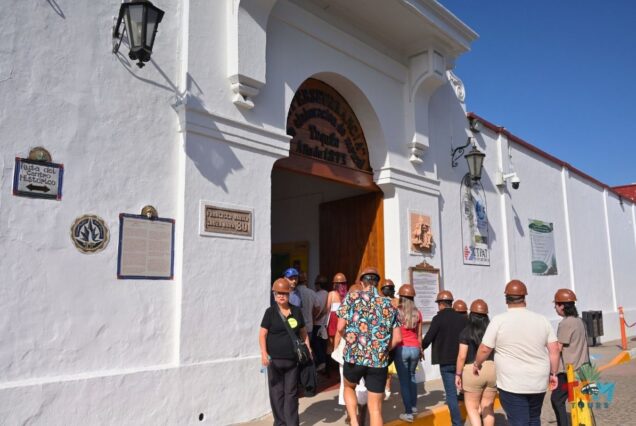 Tourists wearing helmets enter the historic Casa Sauza distillery during the Tequila Express Train tour.