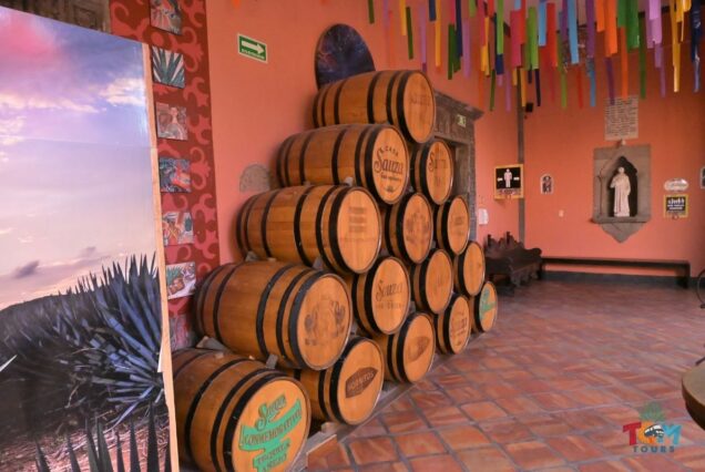 Stacked Casa Sauza tequila barrels inside a tasting room visited during the Tequila Express Train tour.